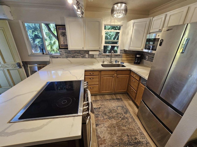 kitchen featuring appliances with stainless steel finishes, decorative backsplash, a sink, and crown molding