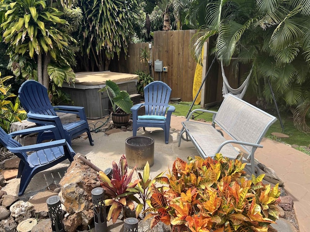 view of patio featuring fence and a hot tub