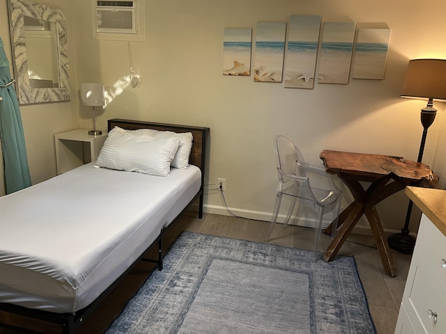 bedroom with wood finished floors and baseboards