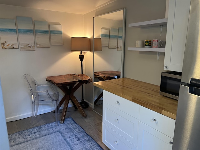 home office with baseboards and wood finished floors