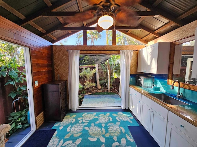 interior space with vaulted ceiling with beams, plenty of natural light, and a sink