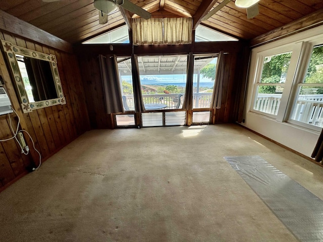 carpeted spare room featuring ceiling fan, wood walls, lofted ceiling, and wood ceiling