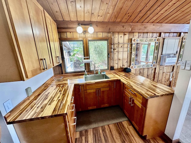 kitchen with wood ceiling, wood walls, butcher block countertops, and sink