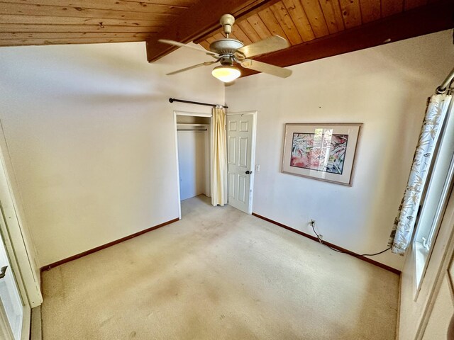 unfurnished bedroom with light carpet, ceiling fan, wood ceiling, and lofted ceiling with beams