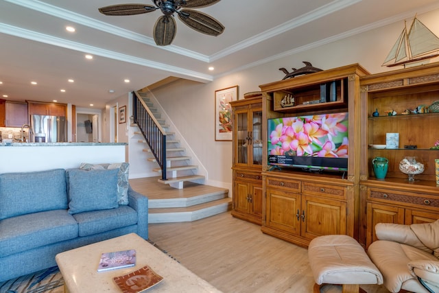 living room with ceiling fan, sink, ornamental molding, and light wood-type flooring