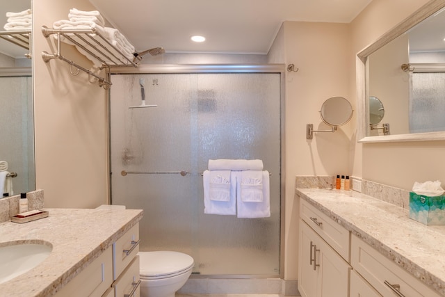 bathroom featuring vanity, toilet, and a shower with door