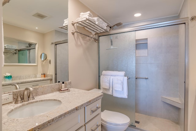 bathroom featuring vanity, toilet, and a shower with door