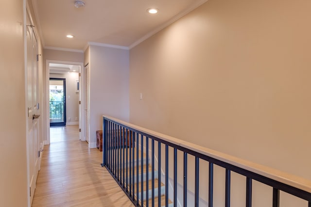 corridor with light wood-type flooring and crown molding