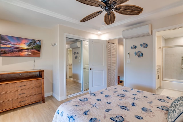 bedroom with a wall mounted air conditioner, ensuite bathroom, ceiling fan, crown molding, and light hardwood / wood-style floors