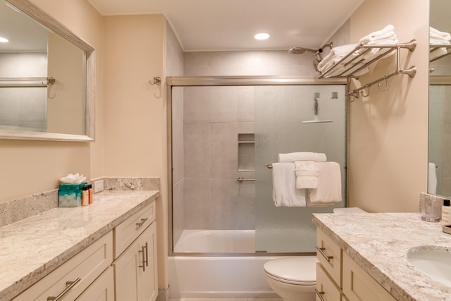 full bathroom with toilet, vanity, and combined bath / shower with glass door