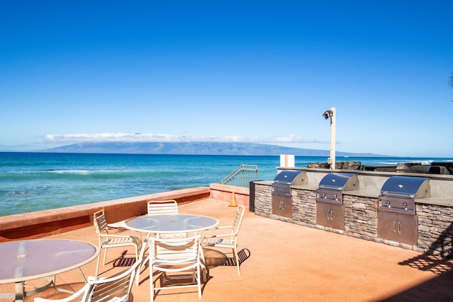 view of patio / terrace featuring area for grilling, a water and mountain view, and a grill