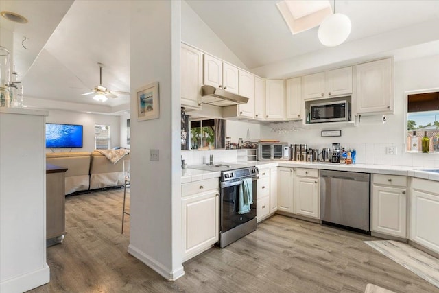 kitchen with decorative light fixtures, appliances with stainless steel finishes, light wood-type flooring, and white cabinetry