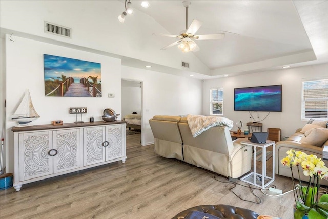 living room featuring wood-type flooring, vaulted ceiling, ceiling fan, and a healthy amount of sunlight