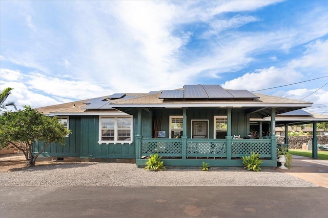 view of front facade with solar panels and a porch