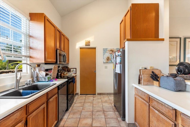 kitchen with light tile patterned flooring, appliances with stainless steel finishes, and sink