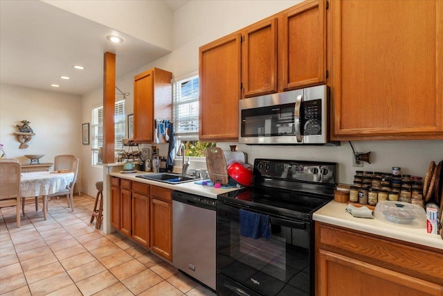 kitchen with light tile patterned floors, appliances with stainless steel finishes, and sink