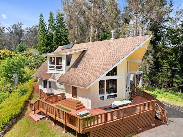 1733 Piiholo Rd, Makawao, HI 96768 - back of property with roof mounted solar panels, a shingled roof, a wooden deck, and view of wooded area