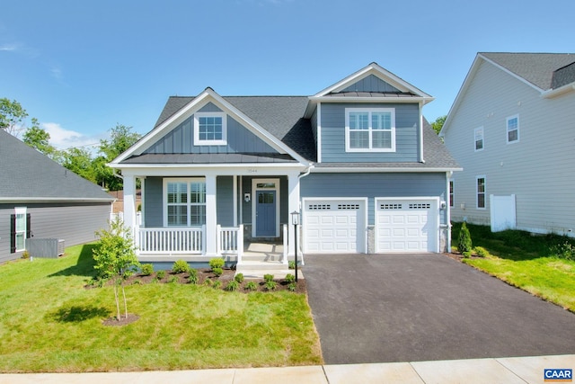 craftsman inspired home with a garage, a front lawn, and covered porch