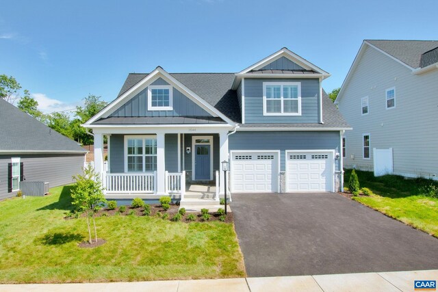 craftsman inspired home with a garage, a front lawn, and covered porch