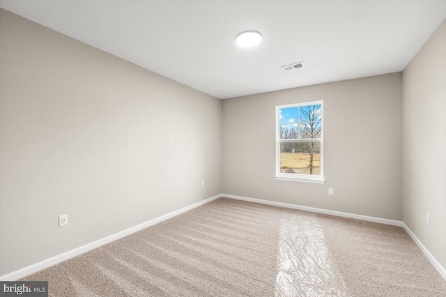 carpeted spare room featuring visible vents and baseboards