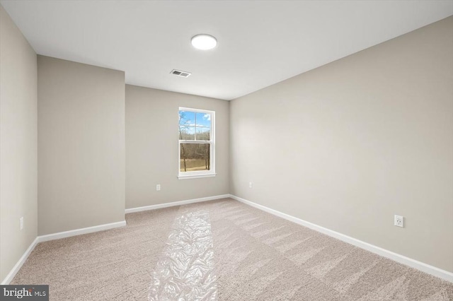 empty room with carpet, visible vents, and baseboards