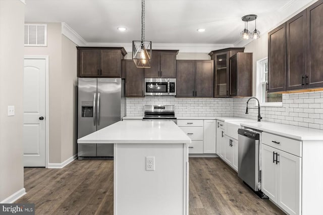 kitchen with stainless steel appliances, light countertops, glass insert cabinets, white cabinets, and a kitchen island