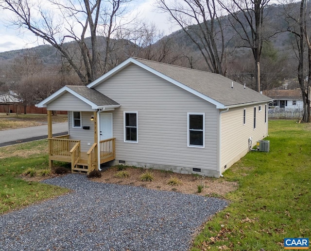 view of front of property featuring a mountain view, a front lawn, and central air condition unit