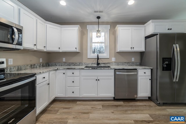 kitchen with white cabinetry, sink, decorative light fixtures, and appliances with stainless steel finishes