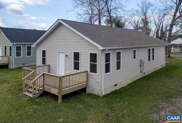 rear view of house featuring a wooden deck and a lawn