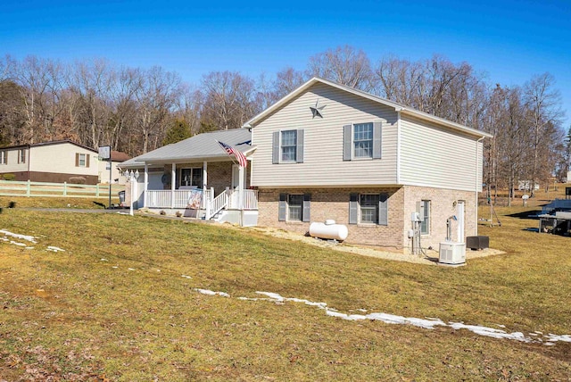 split level home featuring covered porch and a front lawn