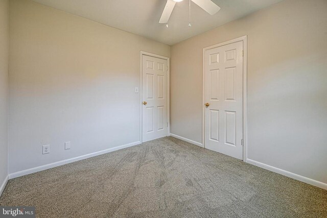 spare room featuring ceiling fan and carpet