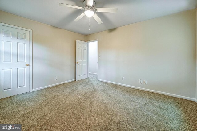 carpeted spare room with ceiling fan