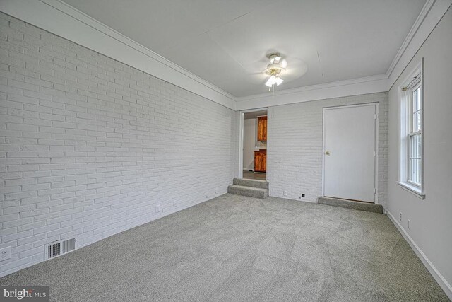 unfurnished bedroom featuring crown molding, brick wall, and light colored carpet