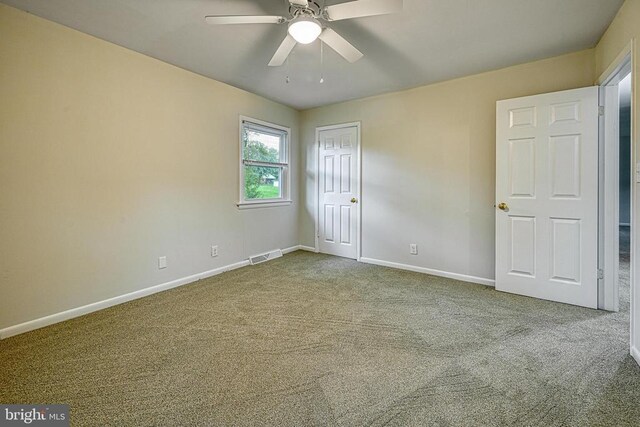 carpeted spare room featuring ceiling fan