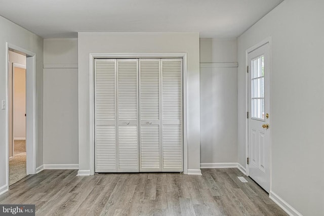 unfurnished bedroom with light wood-type flooring and a closet