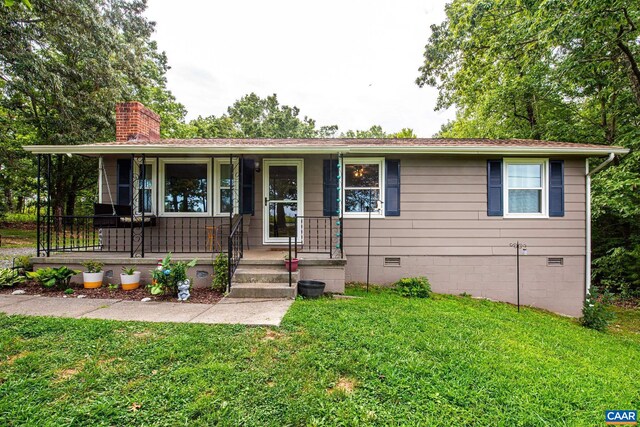 ranch-style home with covered porch and a front lawn