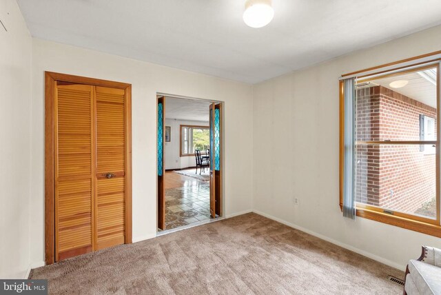 unfurnished bedroom with a closet, carpet flooring, and baseboards