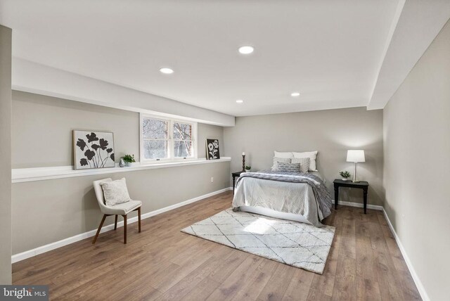 bedroom with baseboards, wood finished floors, and recessed lighting