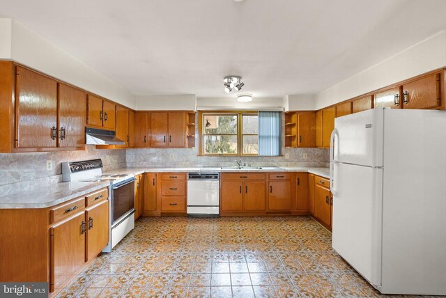 kitchen featuring open shelves, light countertops, brown cabinetry, white appliances, and under cabinet range hood