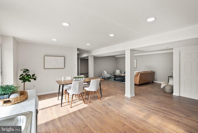 dining room with baseboards, light wood finished floors, and recessed lighting