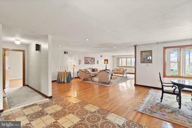 unfurnished living room featuring baseboards, wood finished floors, and a healthy amount of sunlight