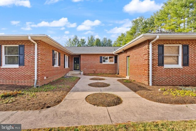 exterior space with brick siding and a patio