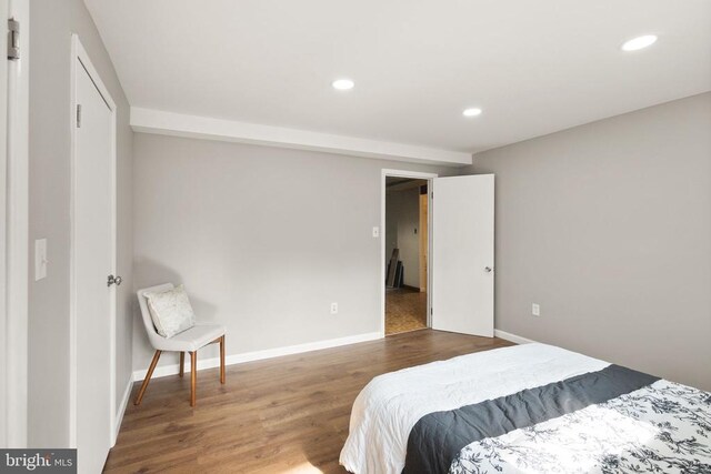 bedroom featuring baseboards, wood finished floors, and recessed lighting