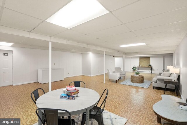 dining room featuring a paneled ceiling and baseboards