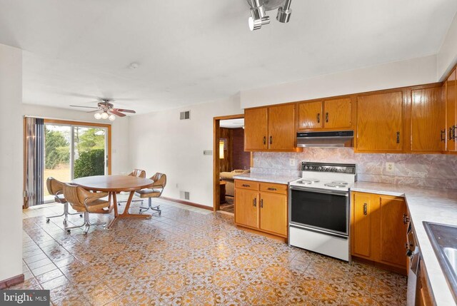 kitchen featuring visible vents, decorative backsplash, light countertops, under cabinet range hood, and white range with electric cooktop