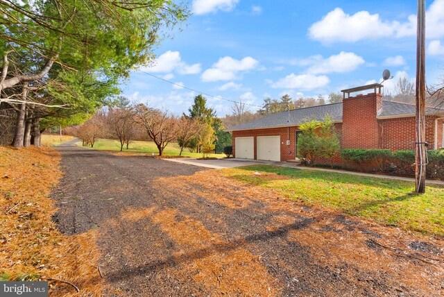 exterior space featuring concrete driveway, brick siding, and an attached garage