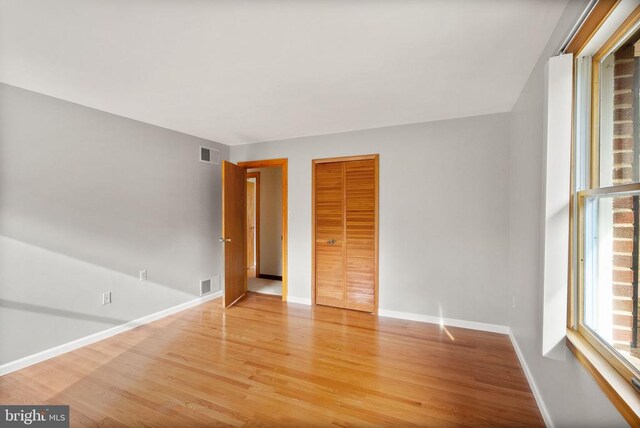 unfurnished bedroom featuring light wood-style flooring, visible vents, and baseboards