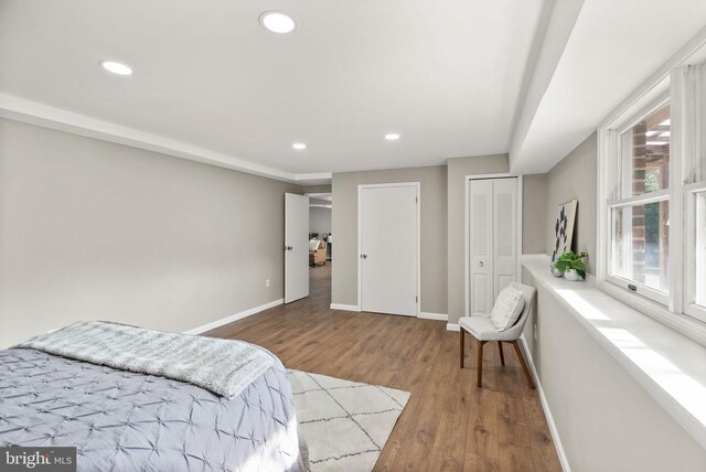 bedroom with baseboards, wood finished floors, and recessed lighting