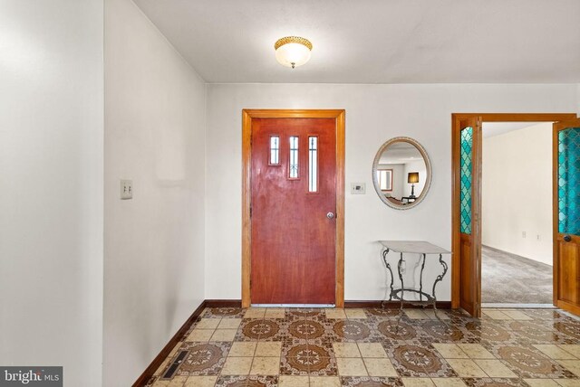 foyer with baseboards and visible vents