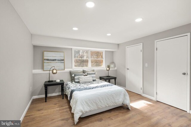 bedroom with baseboards, wood finished floors, and recessed lighting